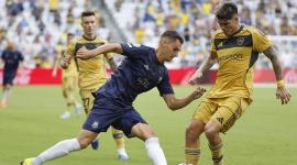 Adam Mitchell (izquierda) de Auckland disputa el balón con Carlos Palacios de Boca este martes 24 de junio, en un partido del Mundial de Clubes.