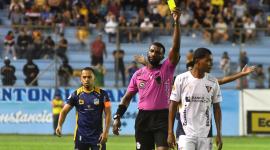 El réferi Lenin Quiñónez saca una cartulina amarilla a Bryan Ramírez, futbolista de Liga de Quito, durante el partido jugado el 6 de julio. Atrás de la acción, el  capitán 'cetáceo', Édison Vega.