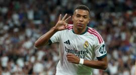 El delantero francés del Real Madrid, Kylian Mbappé (n.º 10), celebra haber marcado un *hat-trick* y el cuarto gol de su equipo durante el partido de la liga española de fútbol entre el Real Madrid CF y la Real Sociedad en el estadio Santiago Bernabéu de Madrid,
