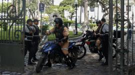 Guardias de seguridad permanecen de pie en una puerta del Parque Seminario en Guayaquil.