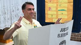 Flavio Bolsonaro, hace el signo de la victoria mientras vota durante las elecciones presidenciales de Brasil.
