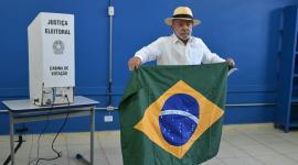 Luiz Inácio Lula da Silva, sostiene una bandera brasileña mientras vota durante las elecciones presidenciales en Brasil.