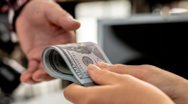 Imagen referencial de una víctima de extorsión entregando dinero