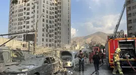 Bomberos trabajan en el exterior de un edificio alcanzado por un ataque israelí al norte de Teherán este 13 de junio.