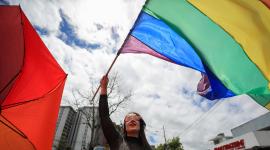 Una integrante de la comunidad LGBT+ ondea una bandera en la Marcha del Orgullo este sábado, en Quito