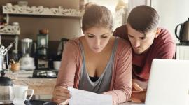 Una joven pareja revisa las cuentas en su casa.