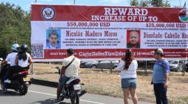 Personas observan una valla con la imagen del presidente de Venezuela, Nicolás Maduro, y del ministro de Relaciones Interiores, Justicia y Paz de Venezuela, Diosdado Cabello, este sábado en Villa del Rosario (Colombia).