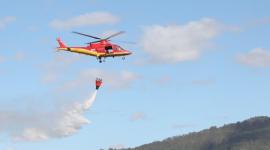 Para sofocar los incendios forestales, los Bomberos utilizan helicópteros que transportan agua.