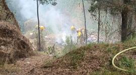 Personal del Cuerpo de Bomberos trabajando en una quema de desechos en Quito.
