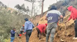 Comuneros y bomberos de Alausí buscan a un niño sepultado por un deslizamiento de tierra.