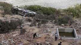 Hombres caminan hacia los restos de un autobús que se precipitó a un barranco de unos 200 metros de profundidad en Arequipa, Perú, el 12 de noviembre de 2025.