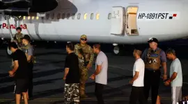 Migrantes caminan frente a un avión tras ser deportados de los Estados Unidos,