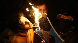 Un hombre prende un cigarrillo en la foto encendida del ayatolá Ali Jamenei.