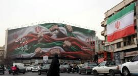 Una mujer iraní cruza una calle cerca de un cartel que dice "Irán es nuestra patria" en la Plaza Enqelab en Teherán, Irán, el 13 de enero de 2026