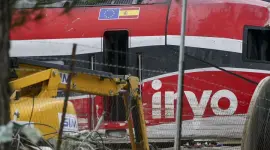 Una grúa trabaja en el vagón 8 del tren Iryo, el último vagón que chocó al descarrilar contra el Alvia.