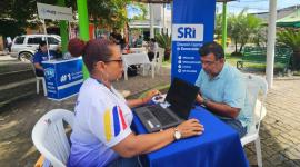 Una funcionaria del SRI da capacitación a un usuario en Esmeraldas durante una feria.