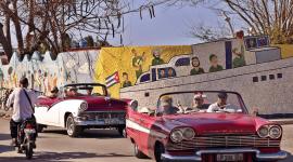 Turistas pasean en autos clásicos frente a un mural del artista plástico Fuster en Jaimanitas este martes, en La Habana (Cuba). La suspensión temporal de todos los vuelos a Cuba desde Canadá deja al turismo de la isla en una posición extremadamente delicada, pues el país norteamericano supone más del 40 % del total de sus visitantes internacionales.