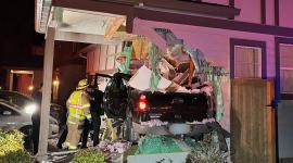 La fotografía muestra una camioneta incrustada en el costado de una vivienda unifamiliar durante la madrugada