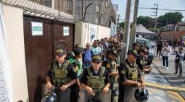 Integrantes de la Policía Nacional de Perú custodian el ingreso al colegio Libertador San Martín este domingo, en Lima (Perú). Hay retrasos en algunos de los centros de votación más importantes.