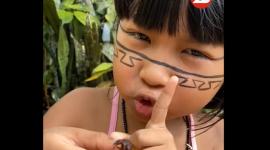 Una niña come una hormiga en el Amazonas.