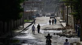 People walk past the rubble of damaged buildings in the aftermath of earthquakes in La Guaira, Venezuela, June 25, 2026. REUTERS/Maxwell Briceno
