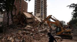 Una persona camina jutno a un edificio totalmente colapsado en Caracas, Venezuela,