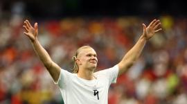 Erling Haaland alza sus brazos en señal de triunfo.