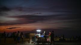 Un vendedor ambulante utiliza una lámpara portátil para vender sus productos a lo largo del Malecón durante un apagón nacional en La Habana.