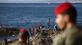Miembros del Ejército español observan a un grupo de migrantes cerca del puesto fronterizo del enclave español de Ceuta, el 2 de agosto de 2026.