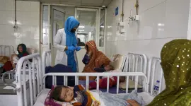 Madres e hijos en la sala de un hospital a la espera de atención.