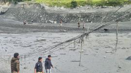 Los lugareños caminan entre el lodo a lo largo de las orillas del río Budhi Gandaki, un día después de la inundación