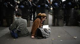 Dos estudiantes protestasn en Francia ante un contingente policial.