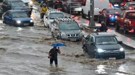 Un hombre camina por aguas anegadas tras fuertes lluvias en el norte de Guayaquil.