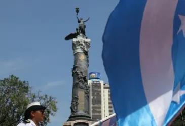 Monumento a los Próceres de la Independencia, en el Parque Centenario de Guayaquil, junto a la bandera de la ciudad.