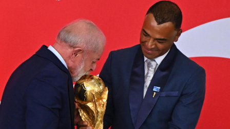 El presidente de Brasil, Luiz Inácio Lula da Silva, besa el trofeo de la Copa Mundial de la FIFA junto al exjugador Cafú durante una ceremonia este jueves, en Brasilia (Brasil).