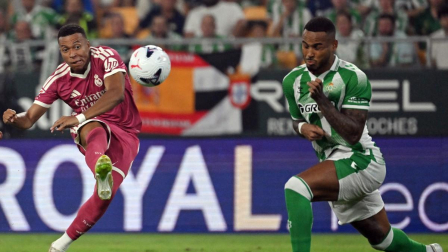 El delantero francés del Real Madrid, Kylian Mbappé (n.º 10), es disputado el balón por el defensa brasileño del Real Betis, Natan Bernardo de Souza (n.º 4, a la derecha), durante el partido de la liga española de fútbol entre el Real Betis y el Real Madrid CF en el estadio Benito Villamarín de Sevilla,
