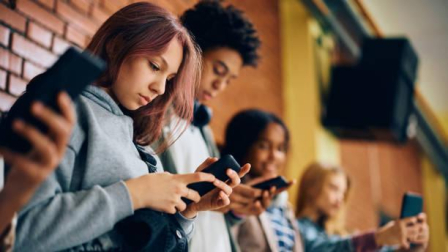 Imagen referencial de estudiantes usando celulares.