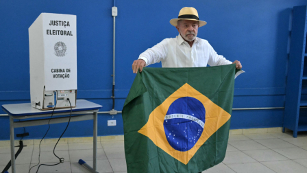 Luiz Inácio Lula da Silva, sostiene una bandera brasileña mientras vota durante las elecciones presidenciales en Brasil.