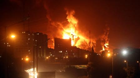 La gente conduce mientras el fuego y el humo se elevan desde el almacén de petróleo de Teherán en Teherán, Irán, el domingo15 de junio de 2024.