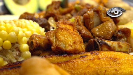 Su origen se remonta a la época colonial, pero ha sido la mano mestiza e indígena la que la transformó en lo que hoy se saborea: carne de cerdo cocinada en su propia grasa, dorada con paciencia y acompañada de mote, llapingachos, plátano maduro, empanadas, según la región y la tradición.