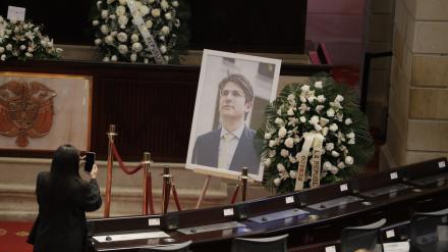 Una persona toma una fotografía a una imagen del fallecido senador y precandidato presidencial de Colombia, Miguel Uribe Turbay, este lunes 11 de agosto, en Bogotá.