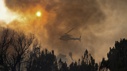 Un helicóptero contra incendios arroja agua sobre un incendio forestal cerca de la aldea de Larouco, en la provincia de Ourense, noroeste de España.