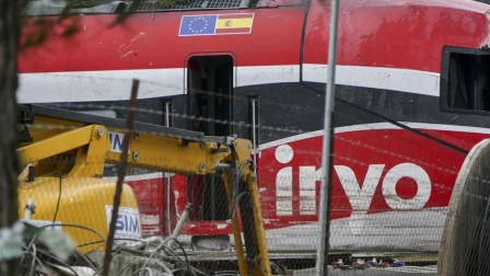Una grúa trabaja en el vagón 8 del tren Iryo, el último vagón que chocó al descarrilar contra el Alvia.