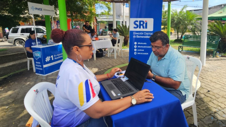 Una funcionaria del SRI da capacitación a un usuario en Esmeraldas durante una feria.