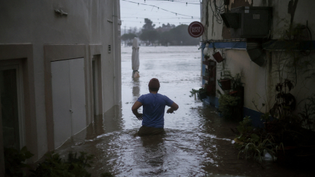 Un hombre en medio de una fuerte inundación tras las lluvias de la tormenta Leo