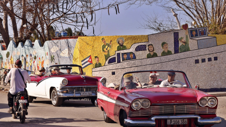 Turistas pasean en autos clásicos frente a un mural del artista plástico Fuster en Jaimanitas este martes, en La Habana (Cuba). La suspensión temporal de todos los vuelos a Cuba desde Canadá deja al turismo de la isla en una posición extremadamente delicada, pues el país norteamericano supone más del 40 % del total de sus visitantes internacionales.