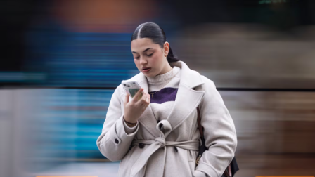 Una persona consulta su móvil en la Gran Via de Barcelona.