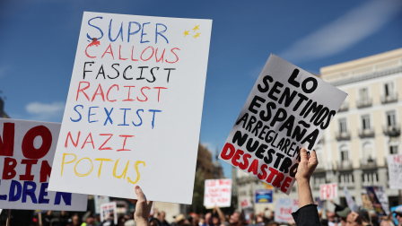 Un manifestante sostiene un cartel que dice "Lo sentimos, España, arreglaremos nuestro desastre" durante una protesta contra las políticas de Donald Trump en el marco del movimiento "No Kings Day" en Madrid, el 28 de marzo de 2026.