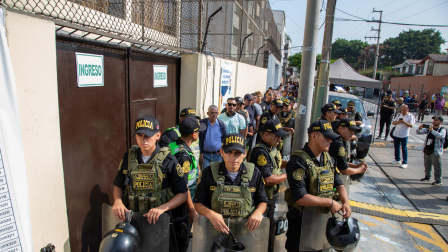 Integrantes de la Policía Nacional de Perú custodian el ingreso al colegio Libertador San Martín este domingo, en Lima (Perú). Hay retrasos en algunos de los centros de votación más importantes.