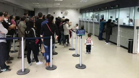 Fila de personas en una ventanilla de banco.